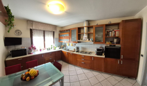Cucina componibile ad angolo e abbinato armadio a muro.