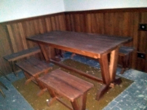 Tavolo in legno massiccio con due panche e due sgabelli.
